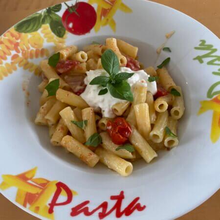 maccheroni mit burrata und tomaten auf teller