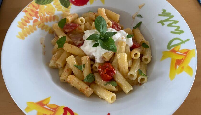 maccheroni mit burrata und tomaten auf teller