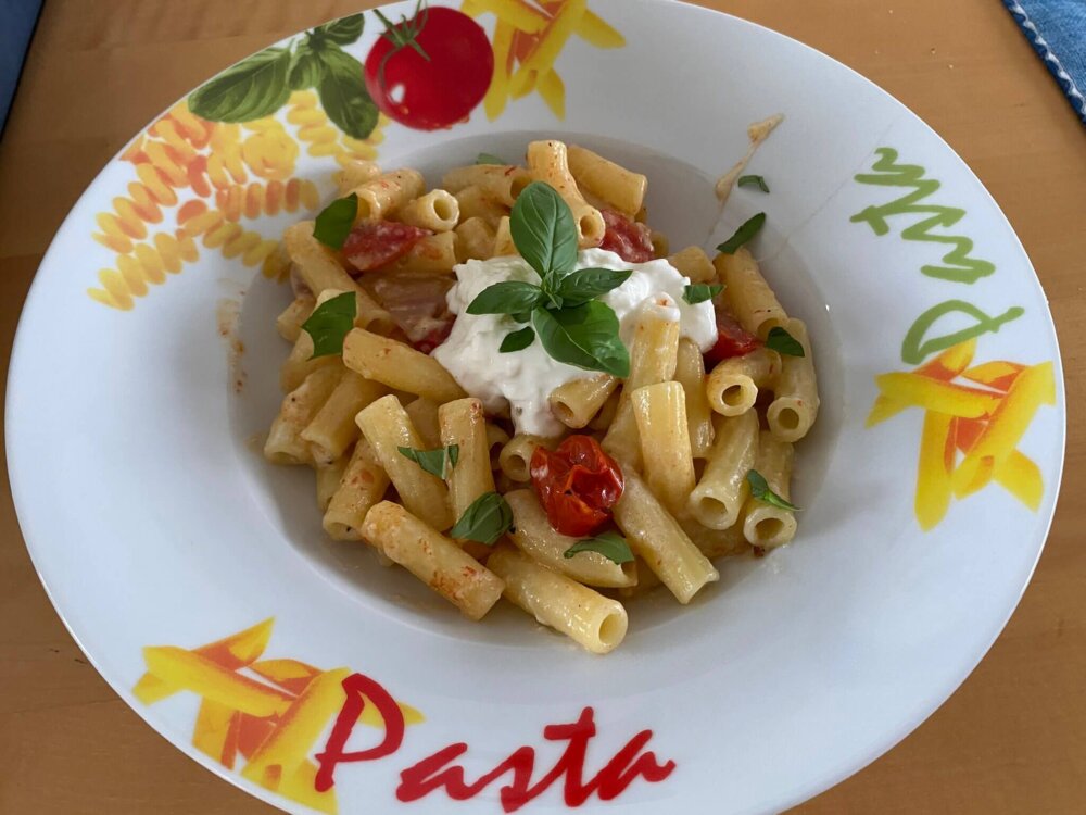 maccheroni mit burrata und tomaten auf teller