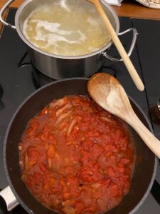 pfanne mit guanciale, zwiebeln und tomaten für spaghetti alla zozzona